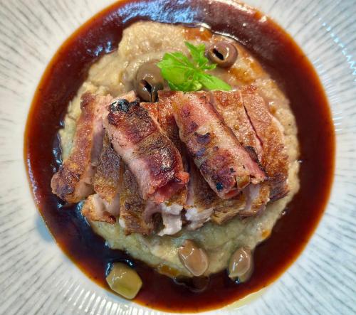 a plate of food with meat and mushrooms and sauce at Landgasthof & Restaurant Batzenhäusl in Sankt Gilgen