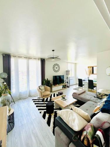 un salon avec un canapé et une table dans l'établissement Appartement proche centre-ville, à Bergerac