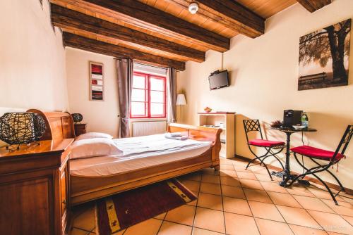 a bedroom with a bed and a desk and two chairs at Aux chambres du Banneret in Neuchâtel