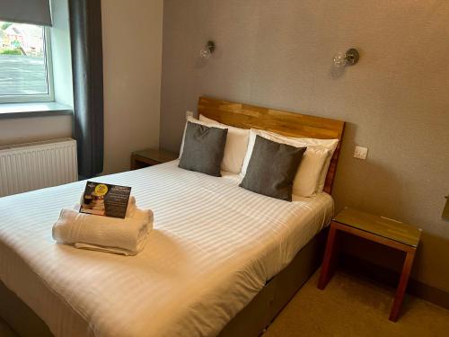 a bedroom with a bed with a book on it at The Valley Hotel, Anglesey in Valley