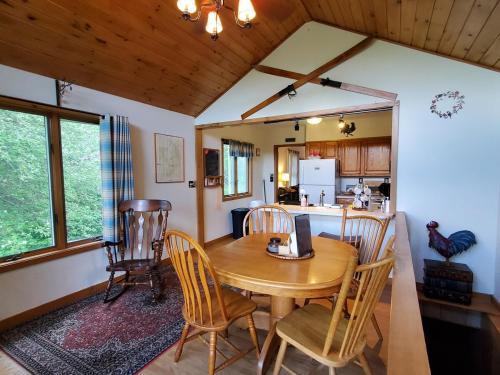 a kitchen and dining room with a wooden table and chairs at Pleasant Brook Cottage in Roxbury