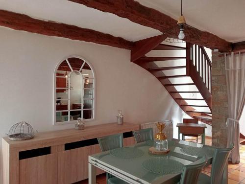 une salle à manger avec une table et un escalier dans l'établissement La Maison du Bonheur, à Mégrit