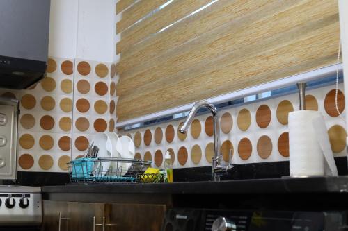 a kitchen counter with a sink and aaucet at Harridon Luxury Apartment 1 in Tema