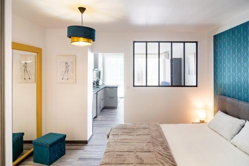 une chambre avec un lit et un mur bleu dans l'établissement Appartement Village Naturiste Irresistible, au Cap d'Agde