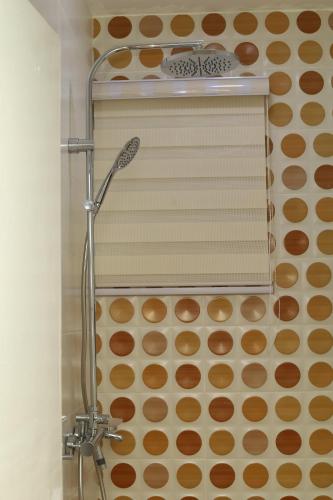 a shower in a bathroom with brown circles on the wall at Harridon Luxury Apartment 1 in Tema