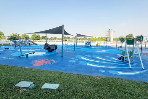 an empty playground with a blue floor and swings at ZAPBED House - Luxury Holiday Homes in Yas Island in Abu Dhabi