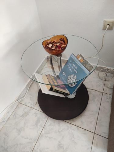 a glass table with a bowl and books on it at Michaella's apartment in Mytilini