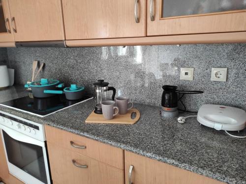 a kitchen with a counter top with cups and appliances at Michaella's apartment in Mytilini