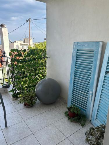 a room with a blue door and some plants at Michaella's apartment in Mytilini