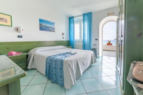 a bedroom with a bed and a view of the ocean at Appartamenti Casa del Sole in Ischia