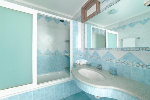 a blue bathroom with a sink and a shower at Appartamenti Casa del Sole in Ischia
