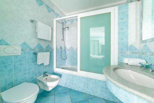 a bathroom with a sink and a toilet and a tub at Appartamenti Casa del Sole in Ischia