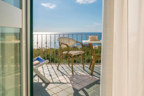 a balcony with a table and chairs and a view of the ocean at Appartamenti Casa del Sole in Ischia