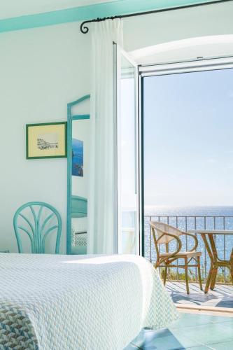 a bedroom with a bed and a view of the ocean at Appartamenti Casa del Sole in Ischia