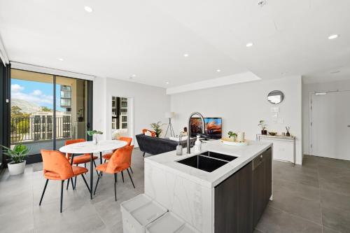 Una cocina y una sala de estar con mesa y sillas. en Sydney Olympic Park Escape w Car Space Height 2m, en Sídney