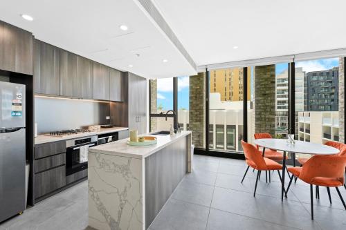 a kitchen with a table and chairs and a table and a table at Sydney Olympic Park Escape w Car Space Height 2m in Sydney