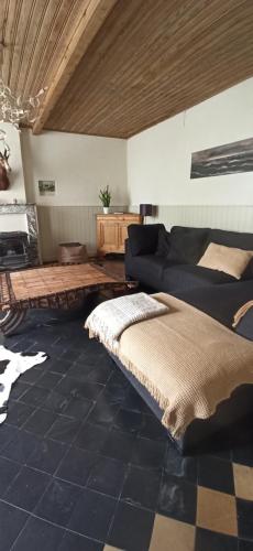 a bedroom with a bed and a couch at Hoeve Korenzegen. Oase van rust dichtbij strand in De Haan