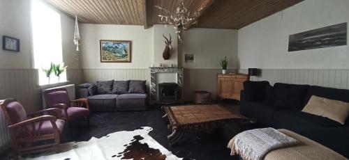 a living room with a couch and a chair and a fireplace at Hoeve Korenzegen. Oase van rust dichtbij strand in De Haan