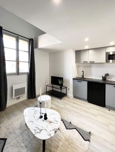 un salon avec une table et une cuisine dans l'établissement CHAL6 Apt moderne à 200m du Capitole, à Toulouse