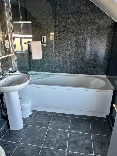 a bathroom with a white tub and a sink at The Valley Hotel, Anglesey in Valley