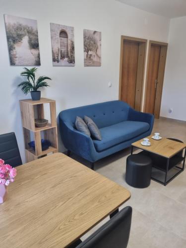 a living room with a blue couch and a table at Apartment Oliva in Krk