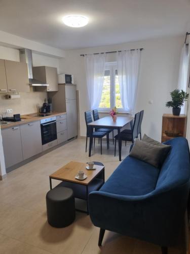 a living room with a blue couch and a table at Apartment Oliva in Krk