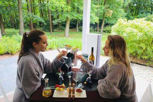 two women sitting at a table with wine glasses at Nooz - Something Different? in Grobbendonk