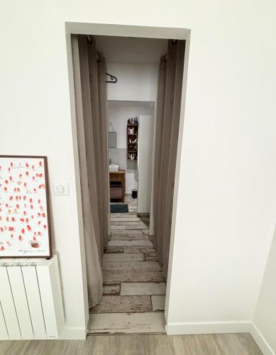 un couloir avec des murs et des sols blancs et un tableau dans l'établissement Maison calme entre mer et marais, à Longeville-sur-Mer