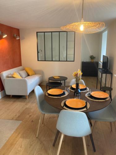 un soggiorno con tavolo, sedie e divano di Studio avec jardin Centre ville a Remiremont