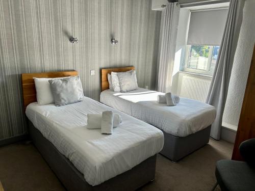 a hotel room with two beds and a window at The Valley Hotel, Anglesey in Valley