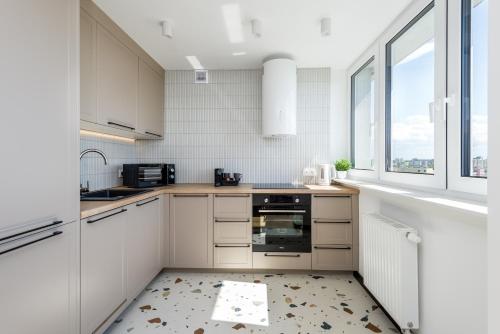 a kitchen with white cabinets and a window at Kairos Apartments - Loft - darmowy parking, ścisłe centrum in Gliwice
