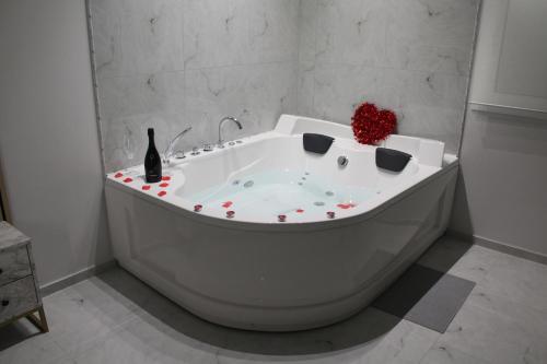 a white bath tub with a red flower on it at Encanto Suites by La Sirenetta in Taormina