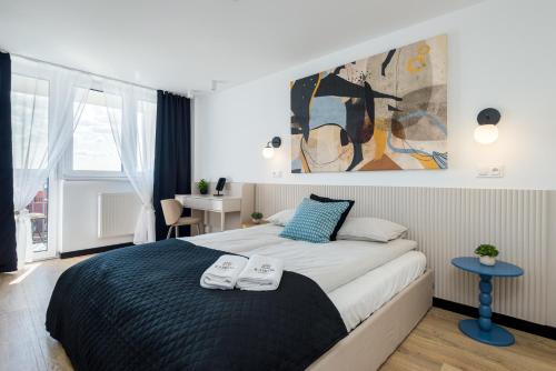 a bedroom with a large bed with two towels on it at Kairos Apartments - Loft - darmowy parking, ścisłe centrum in Gliwice