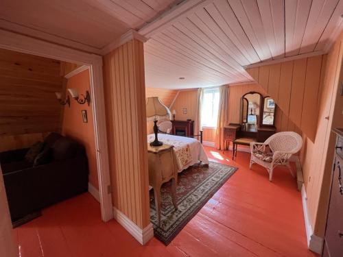a bedroom with a bed and a couch and a table at Maison Hovington in Tadoussac
