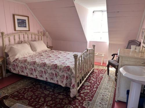a small bedroom with a bed and a sink at Maison Hovington in Tadoussac