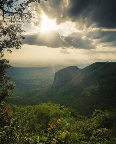 a view of a valley with the sun shining on a mountain at Mount Mulanje Stopover in Peremwe