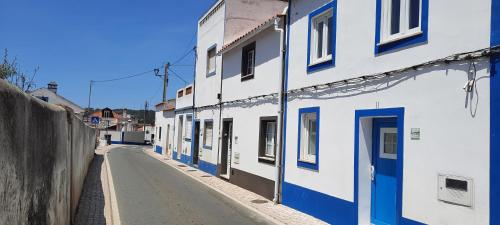 an alley with blue and white buildings on a street at Casa Esmar in Odemira