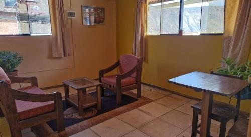 a room with chairs and a table and a window at Chaska valle Inn in Urubamba