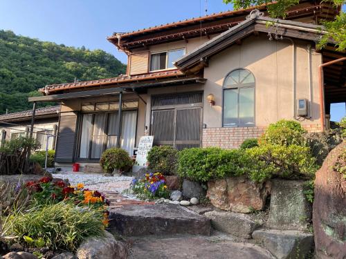 a house with flowers in front of it at うぬまの森かんとりー in Kakamigahara