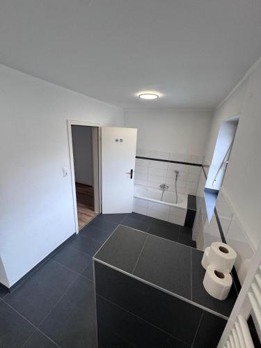 a bathroom with a black floor and white walls at Bavaria Home Apartments in Rohrbach