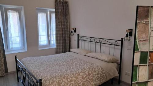 a bedroom with a bed and two windows at Bed&Braja in Vische