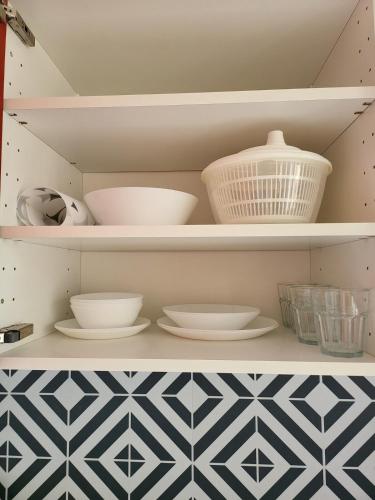 une étagère avec des bols et d'autres plats dans l'établissement Les couleurs de Schiltigheim, à Schiltigheim