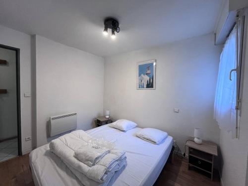 - une petite chambre avec un lit blanc dans l'établissement Charmant Chalet Montagne avec Parking, Proche Navettes - FR-1-812-111, à Cauterets