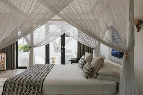une chambre avec un lit à baldaquin dans l'établissement Beachfront Villa in Bali, à Cemagi