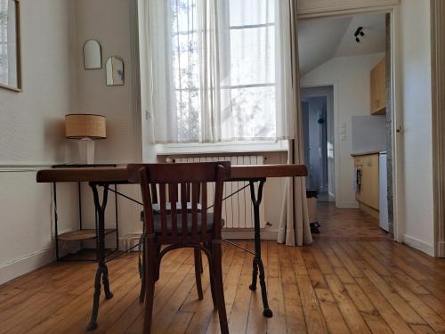 a wooden desk with a chair in a room with a window at Studio plein centre in Dol-de-Bretagne