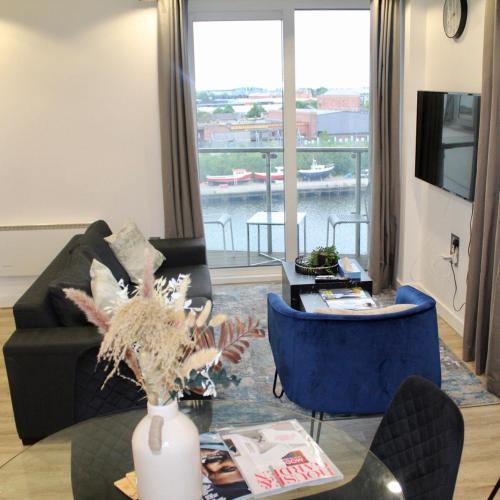 a living room with a couch and a table at Apartment in MediaCity in Manchester