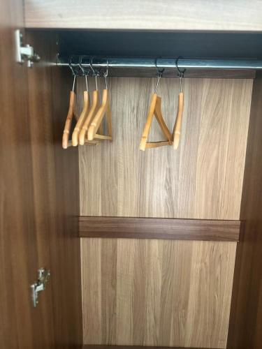 three wooden utensils are hanging from a door at Apartment in MediaCity in Manchester