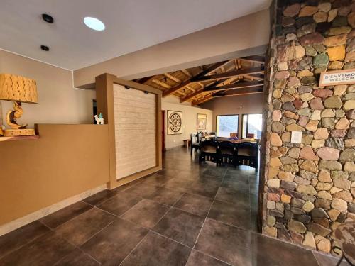 a large room with a stone wall and a door at Hotel y Restaurante Winu Maimara in Maimará