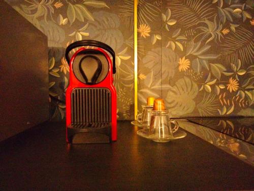 un radiateur rouge assis sur une table à côté d'une bougie dans l'établissement Romantic Studio, à Neuilly-sur-Marne