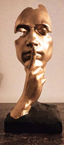 une statue en bronze d'un homme avec son doigt à la bouche dans l'établissement Romantic Studio, à Neuilly-sur-Marne